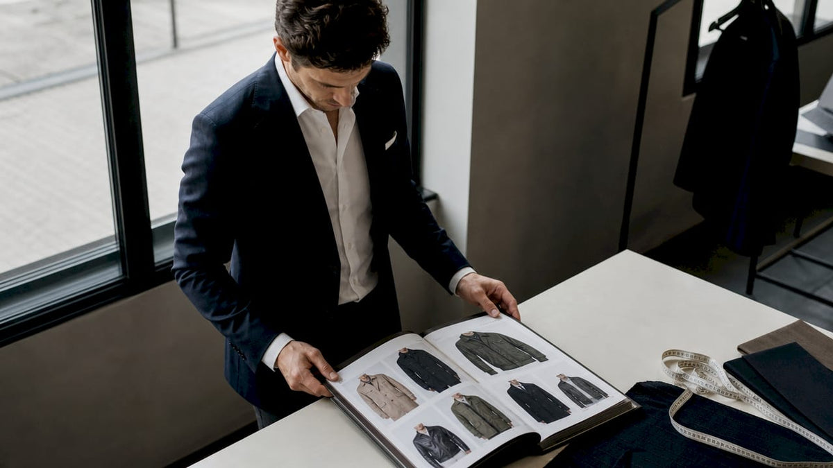 Ein Modeberater wirft einen kritischen Blick auf den aktuellen Katalog für Herrenjacken.